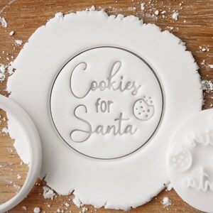 May include: White cookie cutter with the text "Cookies for Santa" and a small cookie graphic.