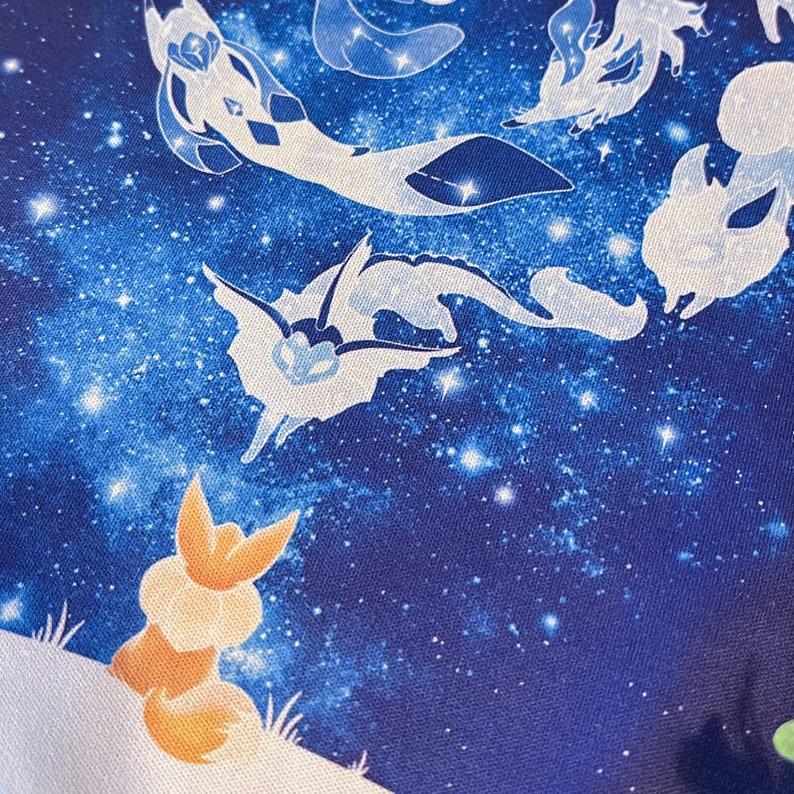May include: A blue and white fabric with a starry night sky design. The fabric features a variety of white silhouettes of mythical creatures, including a fox, a dragon, and a bird.
