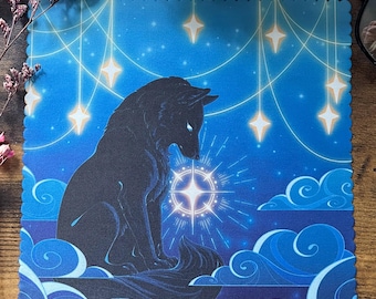 May include: A blue square art print featuring a black wolf silhouette gazing at a glowing star. The background is a gradient of blue with stylized clouds and hanging stars. The print has a scalloped edge.