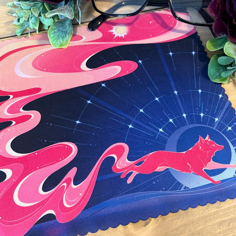 Puede incluir: Una alfombrilla de rat&oacute;n ilustrada con un zorro estilizado corriendo a trav&eacute;s de un cielo nocturno estrellado. El zorro es rosa y el cielo es azul oscuro con estrellas blancas.