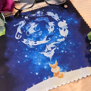 May include: A blue and white mousepad with a galaxy design and a constellation of white foxes. The foxes are arranged in a circle around a central fox.