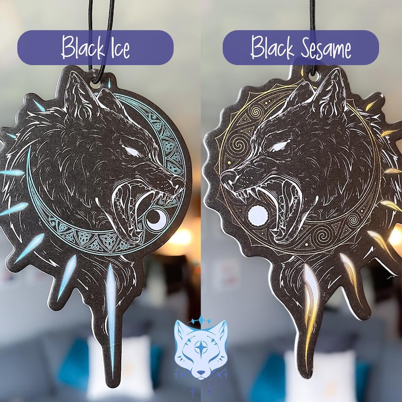 May include: Two black car air fresheners shaped like a wolf's head with a moon and stars design. The left air freshener has a blue and white design and says "Black Ice". The right air freshener has a gold and white design and says "Black Sesame".