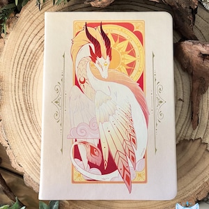 May include: A white and gold dragon with red accents is depicted in an art deco style frame. The dragon is curled up with its wings spread out. The background is a red and gold color with a sun and stars design.