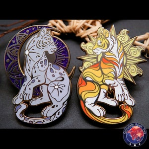 May include: Two enamel pins depicting stylized tigers, one with a crescent moon and the other with a sun. The moon tiger is white with purple and silver accents, while the sun tiger is orange and yellow with gold accents.