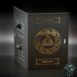 May include: A black card with gold lettering and a gold symbol. The symbol is a circle with a triangle inside. The text on the card says "Haxix" and "Chocolate Raisin Fun".