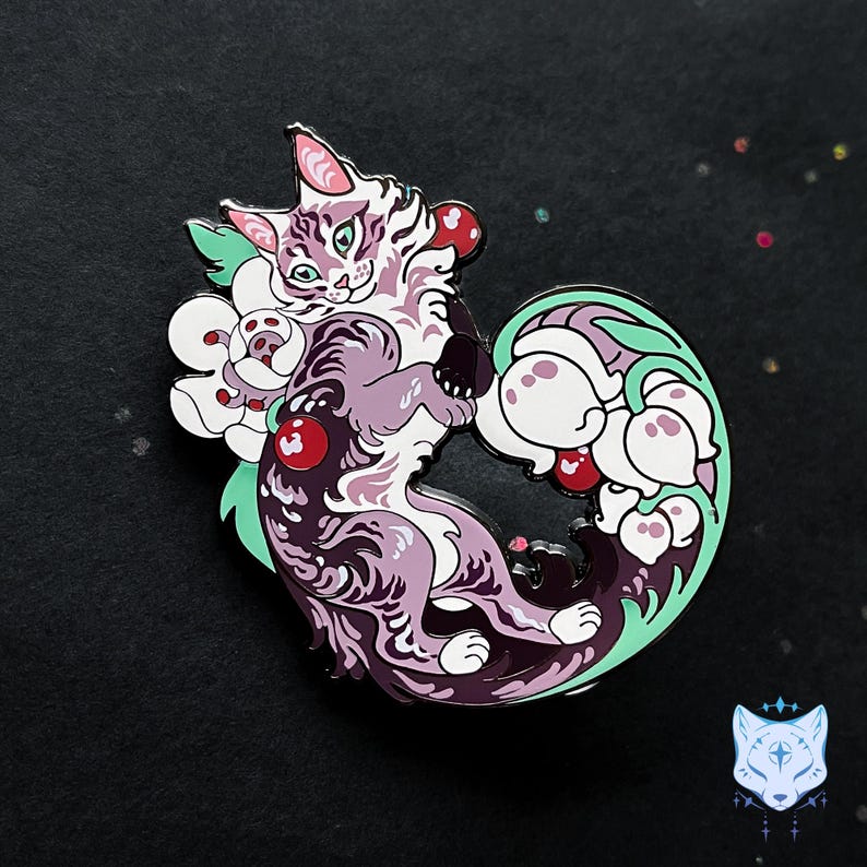 May include: Purple and white enamel pin featuring a stylized cat curled around a cluster of white flowers with red berries. The cat has green eyes and a pink nose.