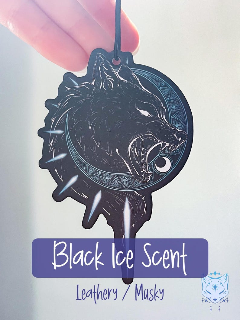 May include: Black car air freshener with a wolf howling at the moon design. The text "Black Ice Scent" and "Leathery / Musky" are printed below the image.