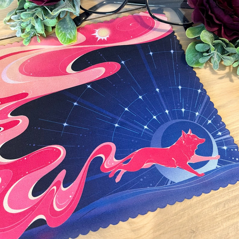 Puede incluir: Un pa&ntilde;o de limpieza de microfibra con estampado azul y rosa con un zorro rojo estilizado corriendo a trav&eacute;s de un cielo nocturno estrellado. El pa&ntilde;o tiene un borde festoneado.