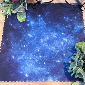 May include: A blue and black microfiber cleaning cloth with a galaxy print. The cloth is designed to clean glasses and other delicate surfaces.