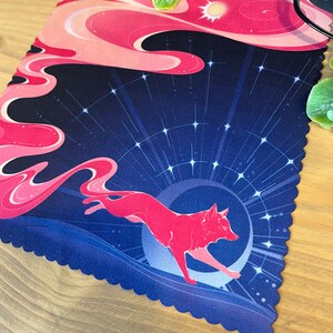 Puede incluir: Una alfombrilla de rat&oacute;n con estampado rosa y azul con un zorro rosa corriendo sobre una luna creciente. El fondo es azul oscuro con estrellas blancas.