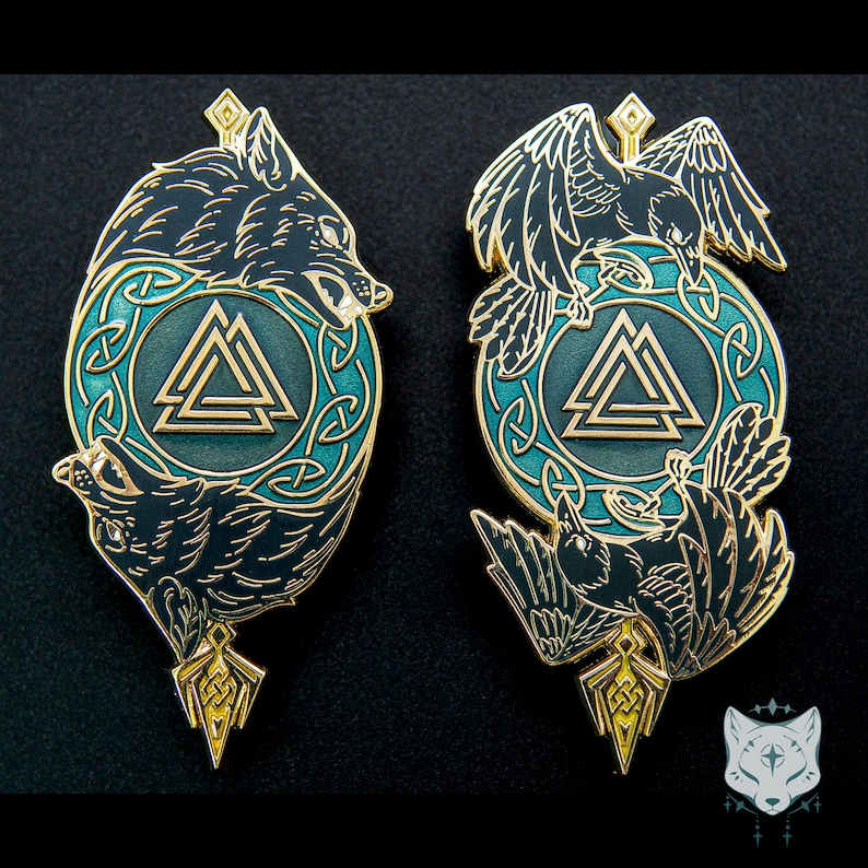 May include: Two gold-toned enamel pins with a black wolf and raven design. Each pin features a circular Celtic knot design with a gold Valknut symbol in the center. The wolf pin has a black wolf howling at the moon, while the raven pin has a black raven with its wings spread.