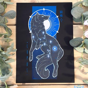 Peut inclure: Une impression noire et bleue d'une constellation de loup avec le texte "Lupus" et "狼座" sur un fond noir.