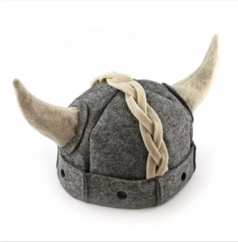 May include: A gray felt Viking hat with a braided strap and two horns. The hat has a pointed top and a rounded shape.