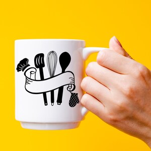 May include: White ceramic mug with a black design of kitchen utensils, including a whisk, a spatula, and a spoon, tied together with a ribbon. The design also includes a chef's hat and a pot holder.