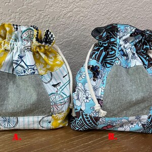Op de afbeelding: Twee trekkoordtassen met patchwork-ontwerpen. De ene tas heeft een fietsprint met gele en blauwe accenten, terwijl de andere een bloemenpatroon in blauw- en bruintinten heeft. Beide tassen hebben een grijs middenpaneel.