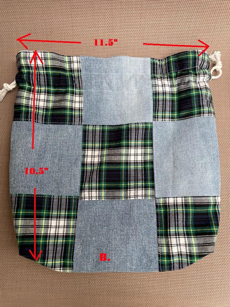 May include: A patchwork drawstring bag, 11.5 inches wide and 10.5 inches tall, featuring denim and green, black, and white plaid fabric squares. The bag has a white drawstring closure and the letter "B." in red.