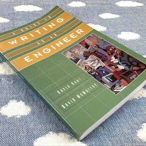 May include: A softcover book titled A Guide to Writing as an Engineer by David Beer and David McMurrey. The cover is green with a grid pattern, a tan horizontal band, and a rectangular illustration showing people working in an office setting.