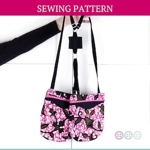 May include: A pink and black floral print crossbody bag with a black strap and a pink zipper. The bag has a small pocket on the front.