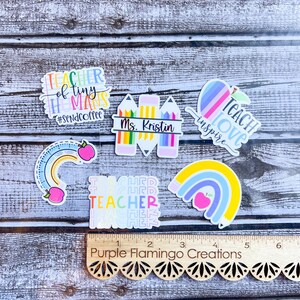 Puede incluir: Un conjunto de cinco pegatinas con tem&aacute;tica de profesor con dise&ntilde;os coloridos. Las pegatinas presentan frases como "Teacher of Tiny Humans #SendCoffee", "Teach Love Inspire" y "Teacher" repetido en un patr&oacute;n de arco&iacute;ris. Tambi&eacute;n hay una pegatina con un arco&iacute;ris y una manzana, y una pegatina con una fila de l&aacute;pices de colores y el texto "Ms. Kristin".