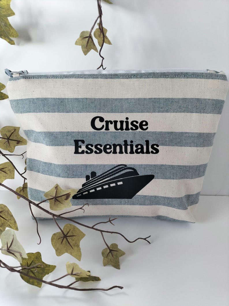 May include: A striped blue and white canvas zippered pouch with the text "Cruise Essentials" and a black silhouette of a cruise ship.