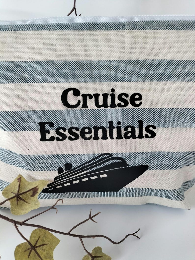 May include: A white and blue striped canvas zippered pouch with the text "Cruise Essentials" and a black silhouette of a cruise ship.