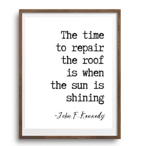 May include: A framed print featuring a black and white quote by John F. Kennedy: "The time to repair the roof is when the sun is shining."