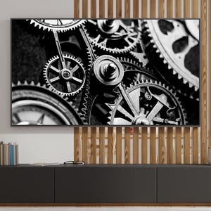 May include: Black and white photograph of a collection of interlocking gears. The gears are arranged in a circular pattern and appear to be made of metal.