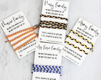 May include: Four cards with different colored friendship bracelets and the words "Marine Family", "Navy Family", "Air Force Family", and "Army Family". Each card has the text "No matter where we go, no matter what we do." and "You'll always be with me & I'll always be with you." with the website "www.rallystrings.com".