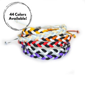 May include: A stack of six colorful braided bracelets in purple, black, white, orange, and yellow. 44 Colors Available! is written in a circle.
