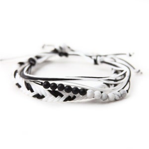 May include: A black and white braided bracelet with black and white beads.
