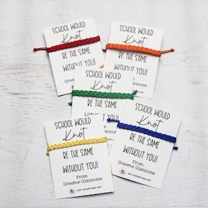 May include: Four colorful friendship bracelets with white cards attached. The cards have the text "School would knot be the same without you!" and a signature. The bracelets are red, orange, green, and blue.