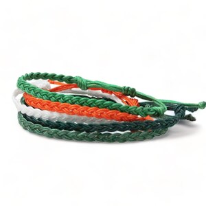 May include: A set of five braided friendship bracelets in green, white, and orange colors. The bracelets are tied together with a knot.