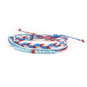 May include: A braided friendship bracelet with red, white, and blue threads. The bracelet has a row of light blue and red beads.