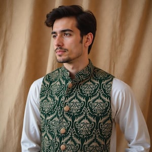 May include: A green and gold patterned vest with gold buttons. The vest has a mandarin collar and is made of a brocade fabric.