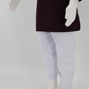 May include: A maroon long-sleeved shirt with white pants. The shirt has a simple design and the pants are plain.