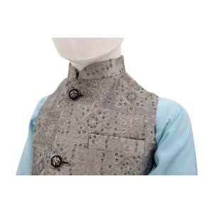 May include: A gray waistcoat with a floral pattern and silver buttons. The waistcoat has a mandarin collar and a pocket on the front.
