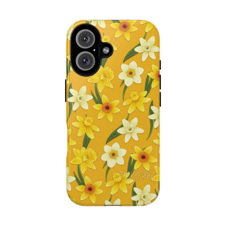 May include: A yellow phone case featuring a repeating pattern of yellow and white daffodils with green leaves. The case has a camera cutout and black side buttons. The text "TACKYFROG" is visible on the bottom right.