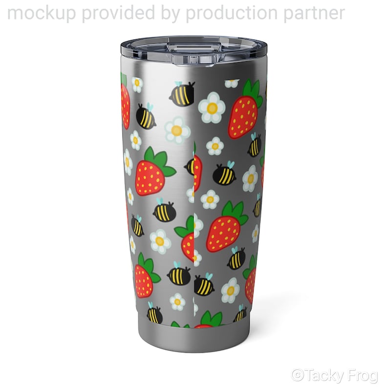 Puede incluir: Un vaso de acero inoxidable con un patr&oacute;n caprichoso de fresas rojas, abejas amarillas y negras y margaritas blancas sobre un fondo gris. El vaso tiene una tapa y una base plateadas.