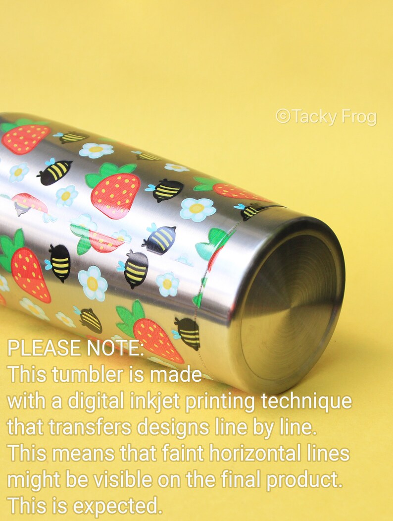 Puede incluir: Vaso de acero inoxidable con un colorido dise&ntilde;o de fresas, abejas y flores. El texto "Tacky Frog" es visible. El vaso est&aacute; hecho con una t&eacute;cnica de impresi&oacute;n digital de inyecci&oacute;n de tinta. Pueden ser visibles l&iacute;neas horizontales.