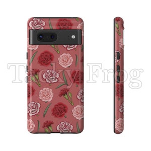 May include: A phone case with a floral pattern of red and pink carnations and green leaves on a dusty rose background. The case has a black border and a camera cutout. The text "Tacky Frog" is visible on the case.
