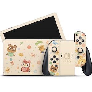 Può includere: Una console Nintendo Switch con finitura color crema e design a tema Animal Crossing. La console presenta un dock abbinato e controller Joy-Con decorati con illustrazioni di personaggi e colori pastello. Lo schermo è nero.