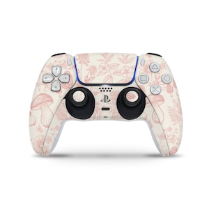 Può includere: Un controller PlayStation 5 DualSense bianco con un motivo floreale rosa e bianco con funghi e foglie.