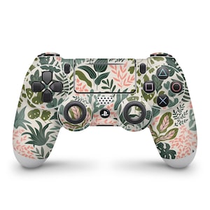 May include: A white PlayStation 4 controller with a floral pattern featuring green leaves and pink flowers.