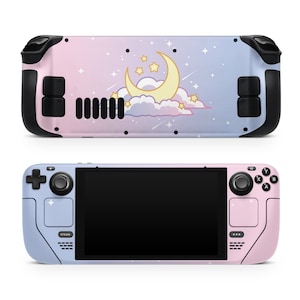 May include: A pink and blue gaming console with a moon and stars design. The console has a black front and a pink and blue back.