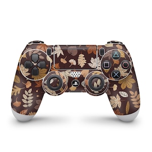 May include: A black PlayStation 4 controller with a brown and gold leaf pattern. The controller has a black d-pad, face buttons, and analog sticks.