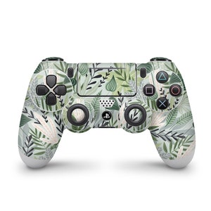 Può includere: Un controller PlayStation 4 verde e bianco con un motivo floreale. Il controller ha una piastra frontale nera con il logo PlayStation e pulsanti.