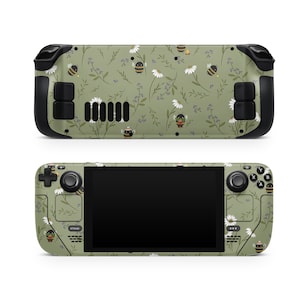 May include: A green and black handheld gaming device with a floral pattern featuring bees and daisies. The device has a black screen and buttons.
