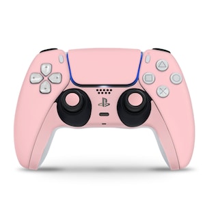 May include: A pink PlayStation 5 DualSense wireless controller with black face buttons and analogue sticks.