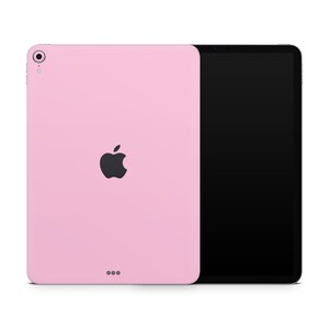 May include: A pink iPad with a black Apple logo on the back. The iPad is on a white background.