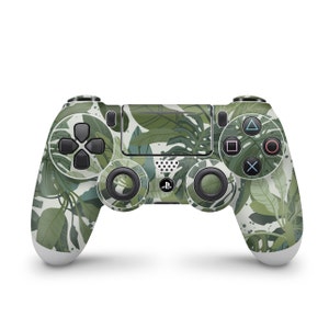 May include: A green and white PlayStation 4 controller with a tropical leaf pattern. The controller has the standard PlayStation buttons and a black D-pad.
